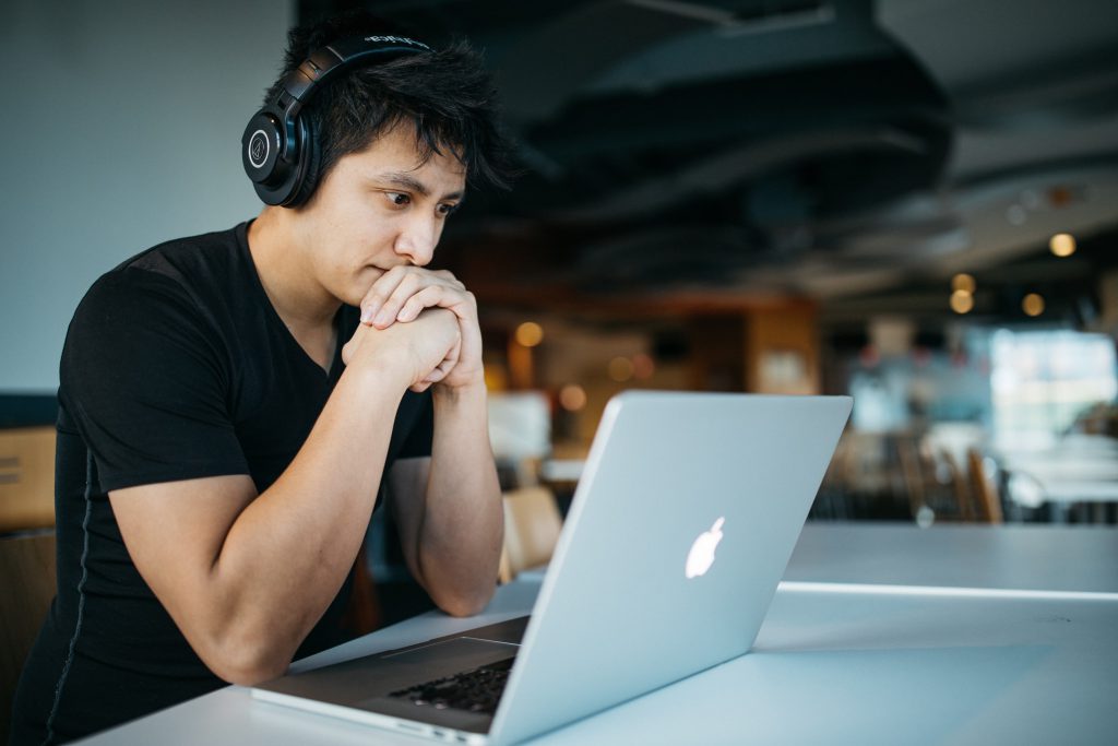 Boy with headphones using a MacBook